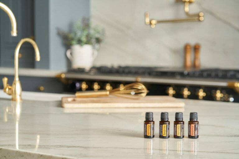 A stylish kitchen counter featuring essential oils with a chic marble texture and brass accents.